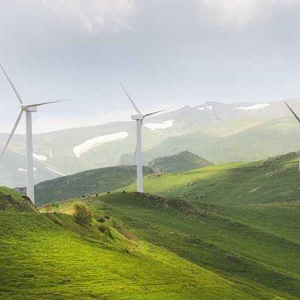 A row of wind turbines on green hills