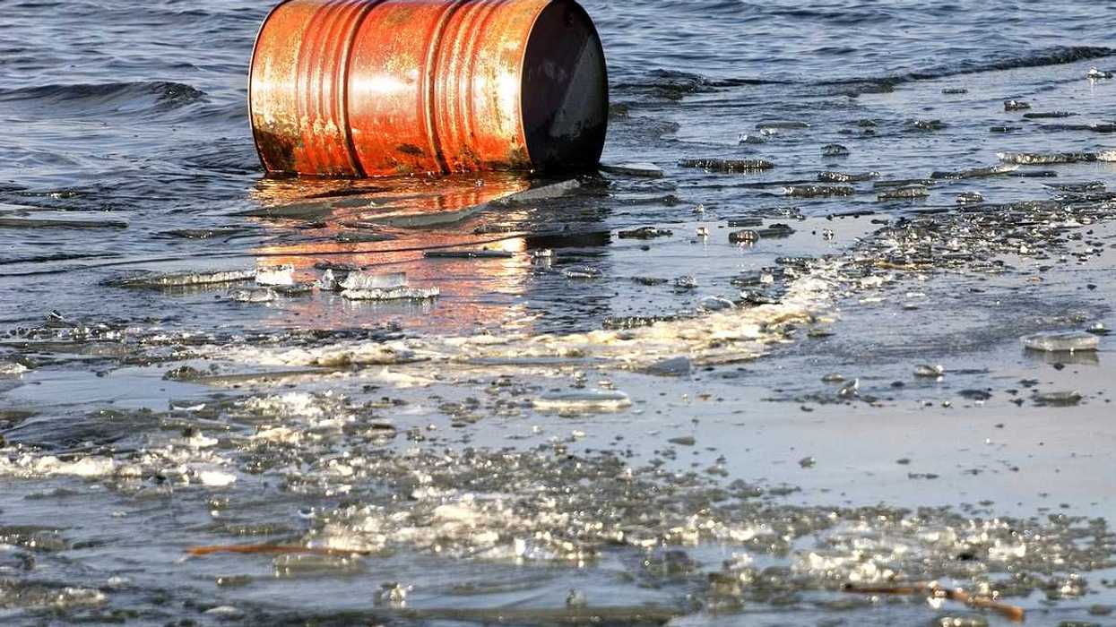 A rusty oil barrel floating in icy water