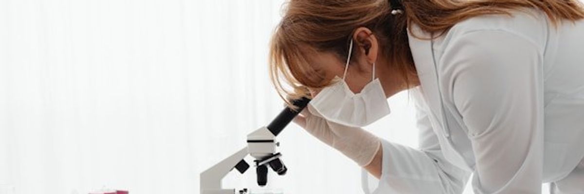 A scientist looking into a microscope