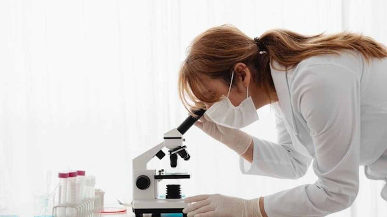 A scientist looking into a microscope