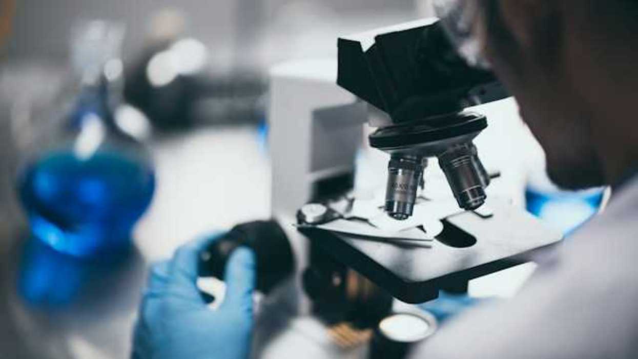 A scientist peering through a microscope