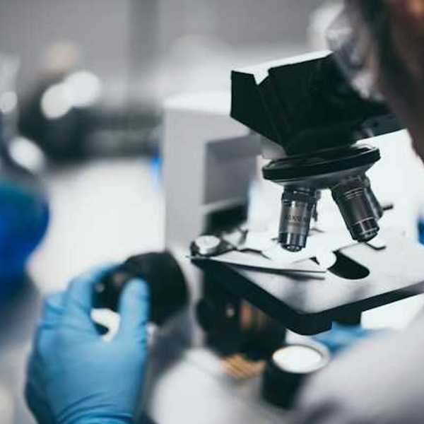 A scientist peering through a microscope
