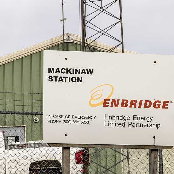 A sign that says Enbridge Energy Limited Partnership in front of a green warehouse