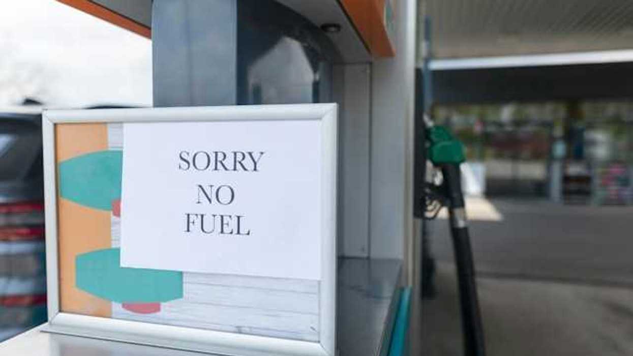 A sign that says 'sorry no fuel' next to a gas station pump
