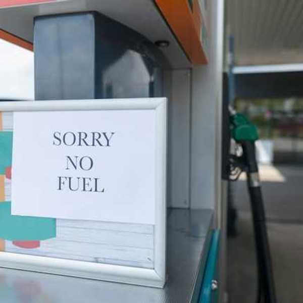 A sign that says 'sorry no fuel' next to a gas station pump