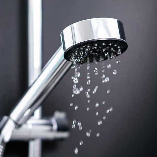 A silver shower head with water coming out of it