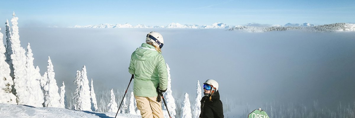A skier and snowboarding on top of a slope