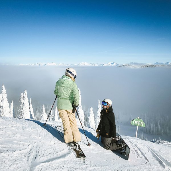 A skier and snowboarding on top of a slope