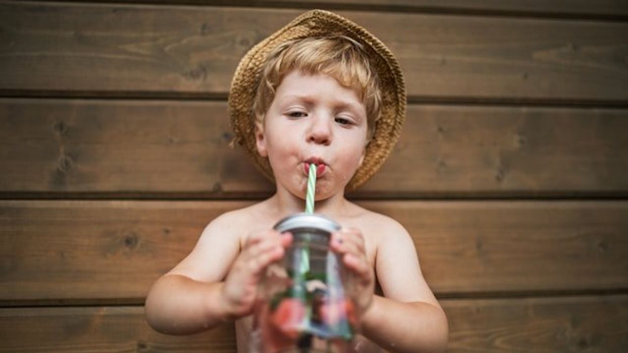 A small boy drinking out of a straw