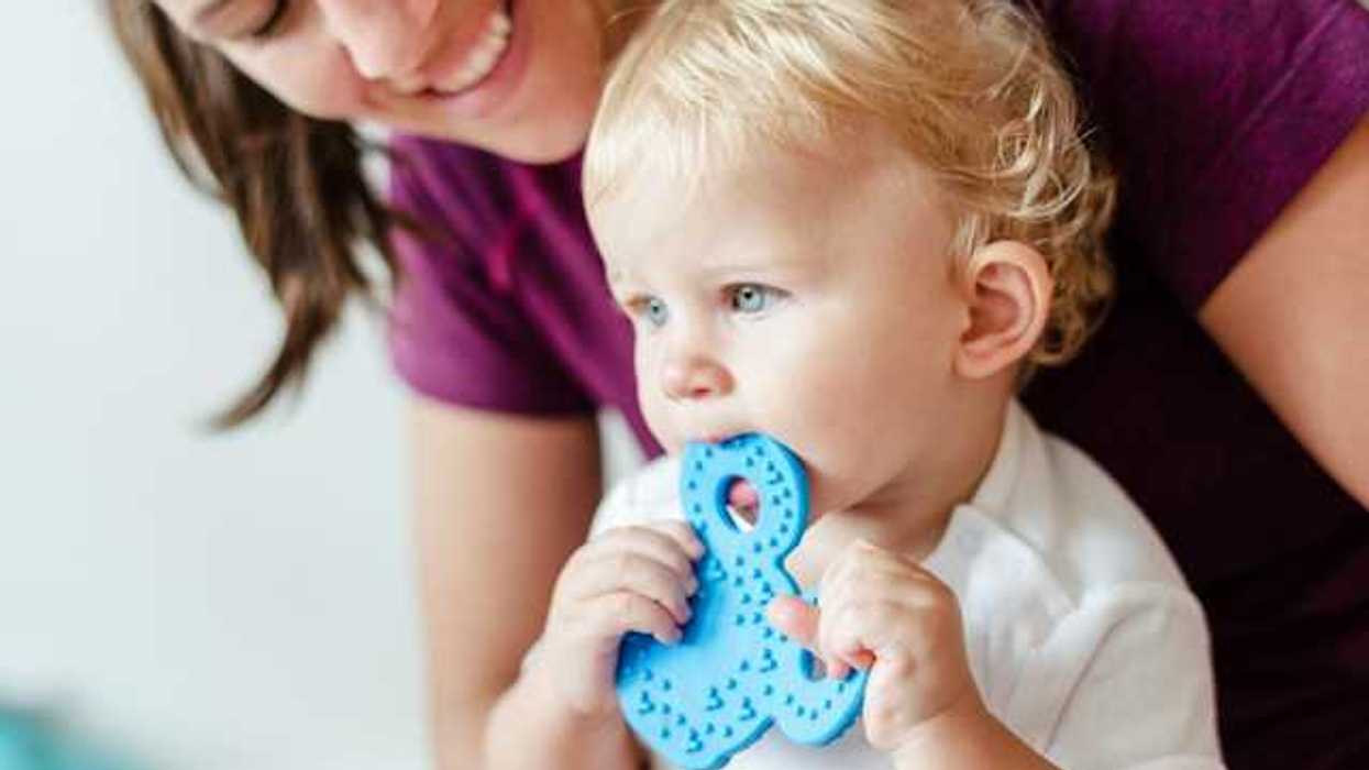 A small child chewing on a plastic toy