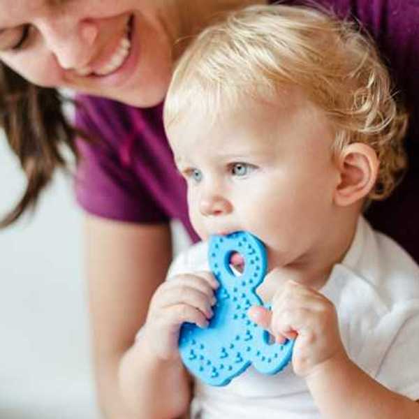 A small child chewing on a plastic toy