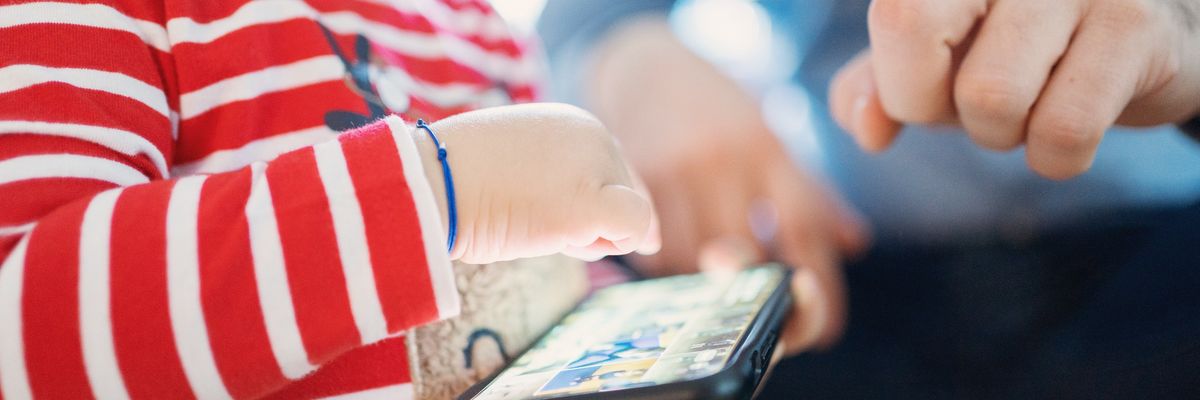 A small child plays with a cell phone