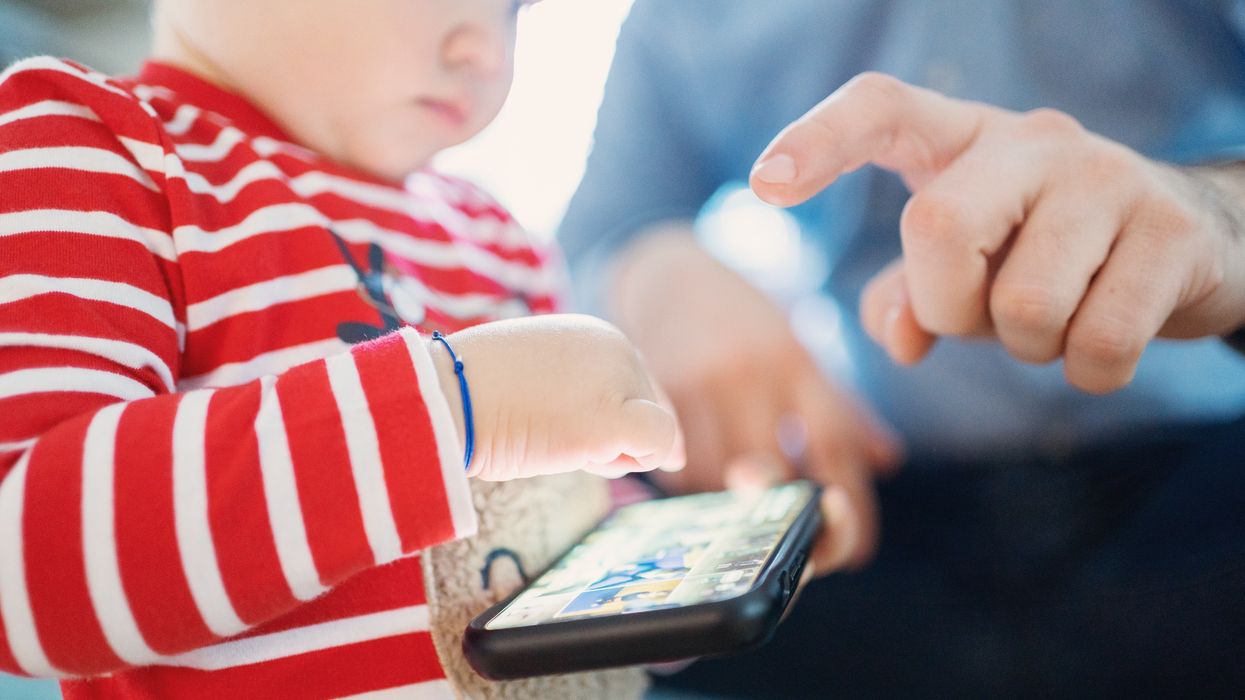 A small child plays with a cell phone