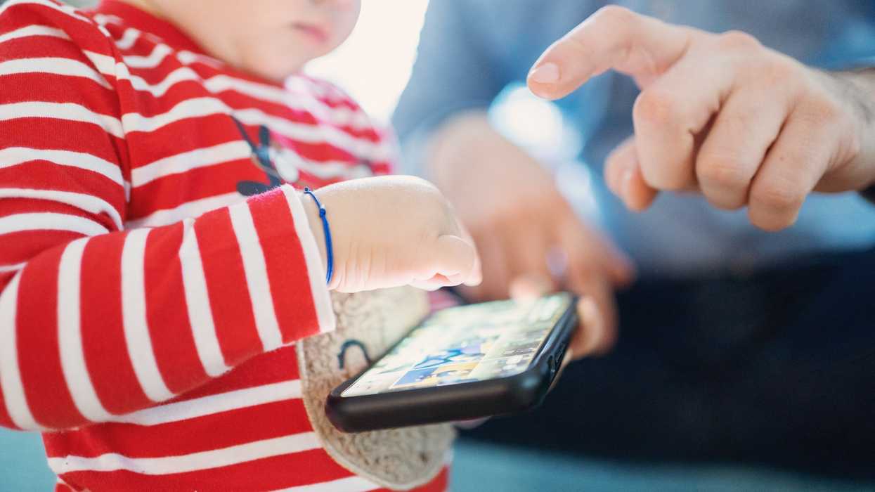 A small child plays with a cell phone