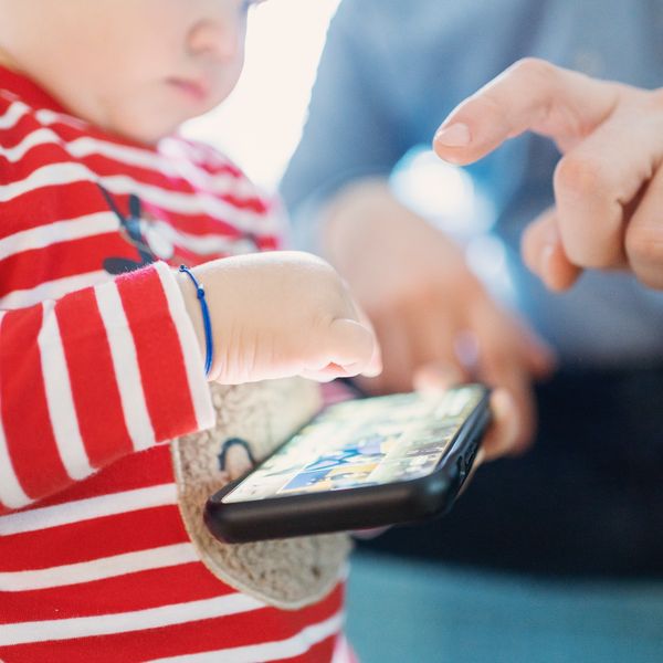 A small child plays with a cell phone