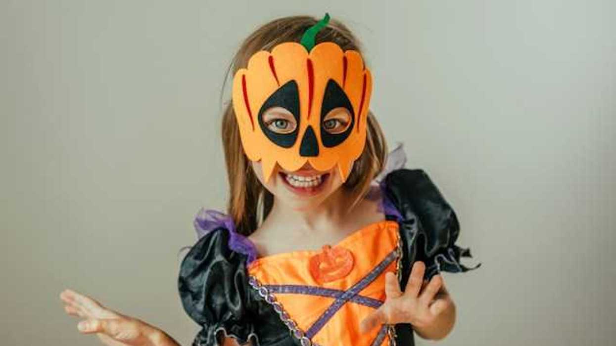 A small girl wearing a Halloween costume