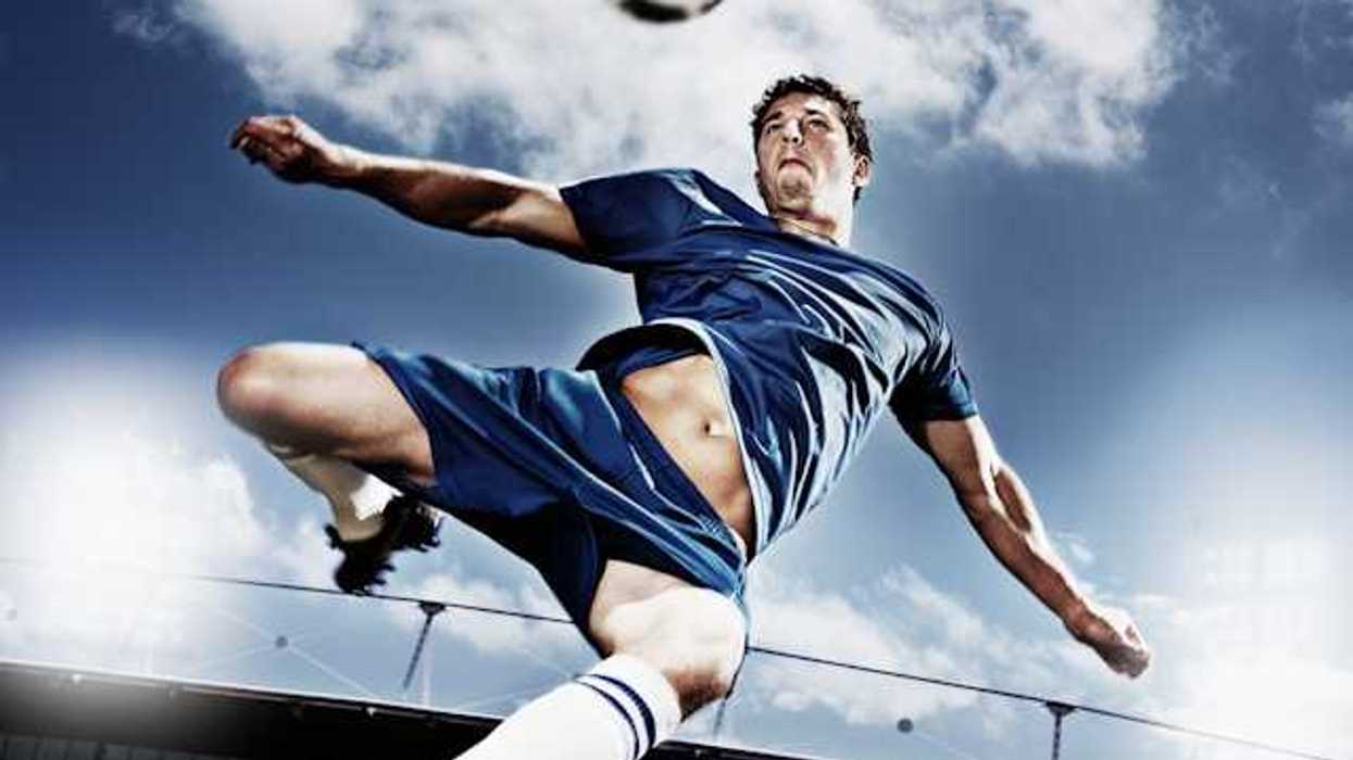 A soccer player kicking a soccer ball