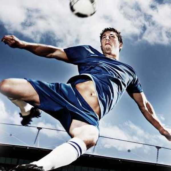 A soccer player kicking a soccer ball