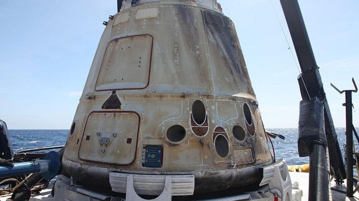 A spaceX rocket part being lifted from the ocean.