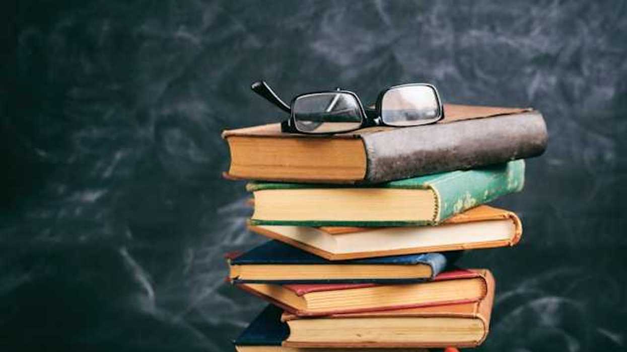 A stack of books with a pair of readers sitting atop it