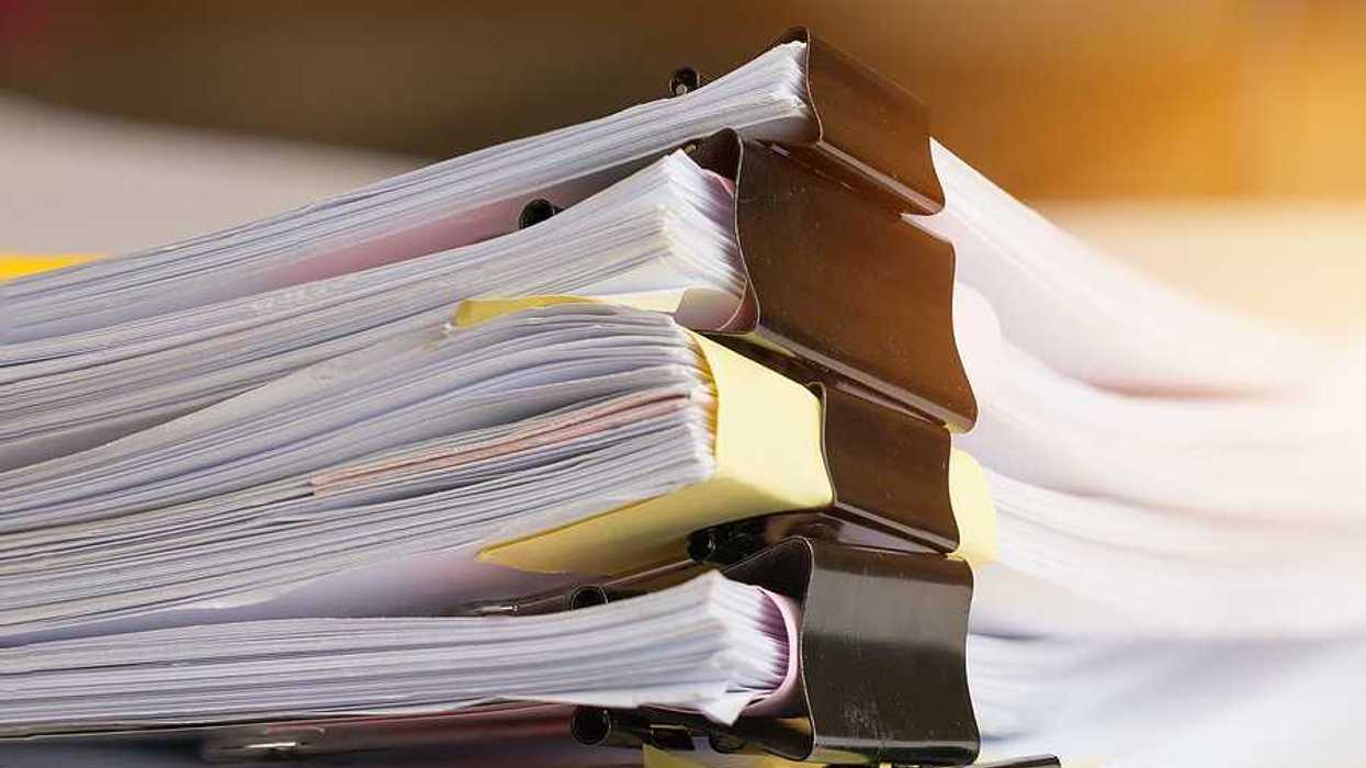 A stack of paperwork with big metal clips holding them together