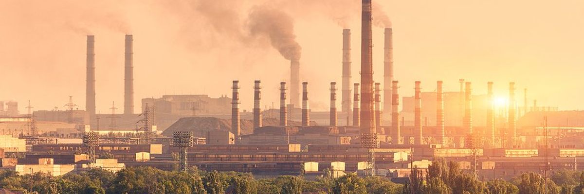 A steel plant with smoke billowing from smokestacks.