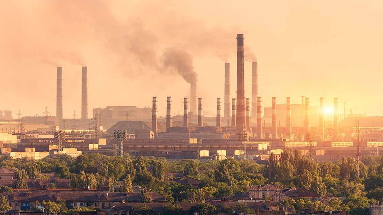 A steel plant with smoke billowing from smokestacks.