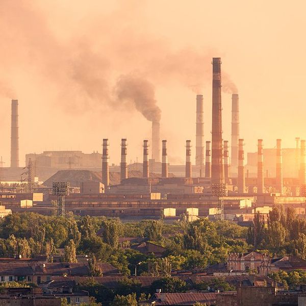 A steel plant with smoke billowing from smokestacks.