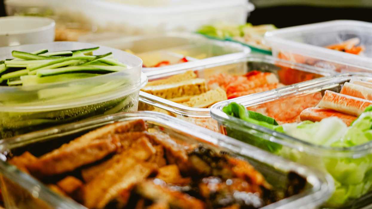 a table topped with lots of different types of food in plastic tupperware.