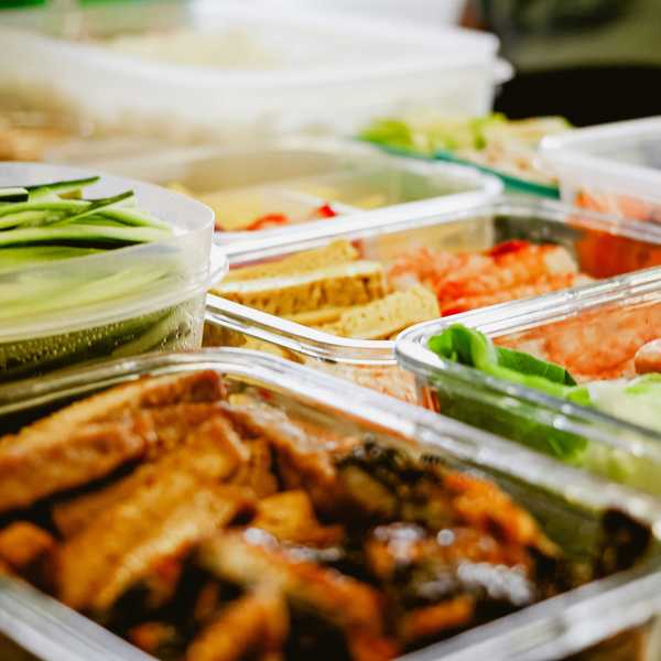 a table topped with lots of different types of food in plastic tupperware.