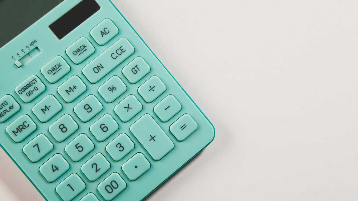 A teal calculator rests on a white surface.