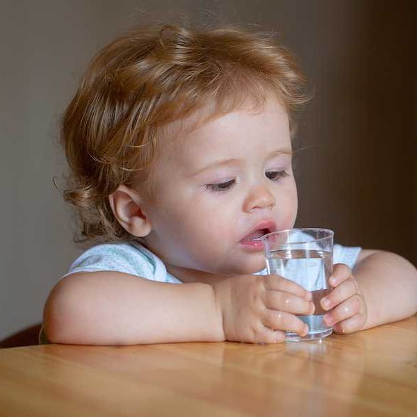 A toddler drinking water out of a cup