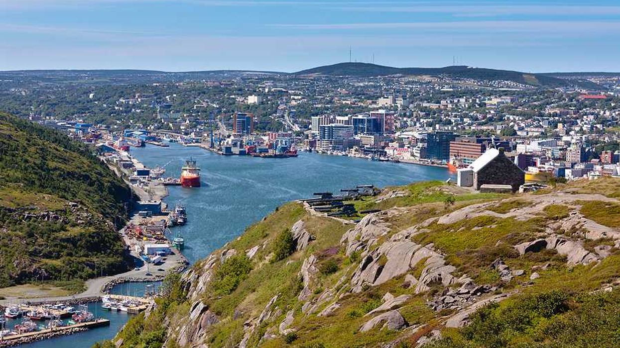 A town in Newfoundland, Canada with water and green hills surrounding it