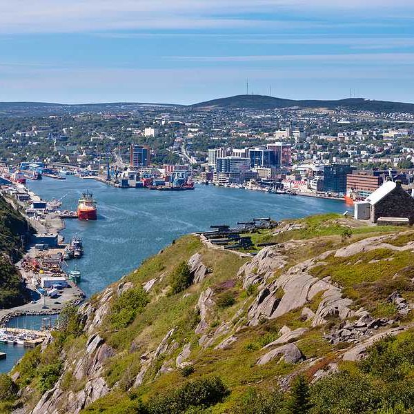 A town in Newfoundland, Canada with water and green hills surrounding it