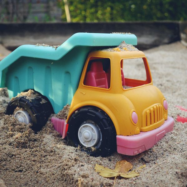 a toy dump truck is in the sand