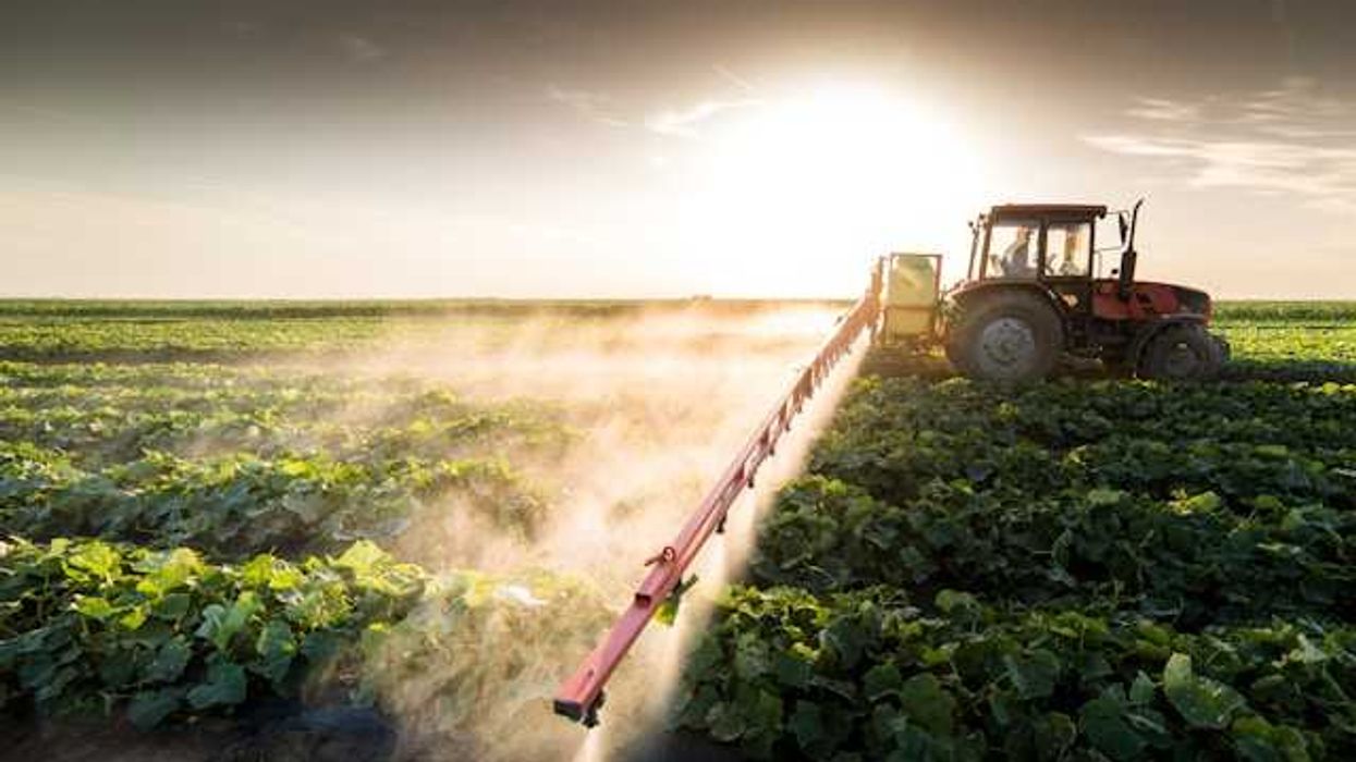 A tractor applying pesticides to a field