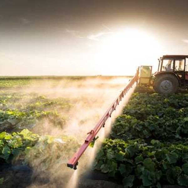 A tractor applying pesticides to a field