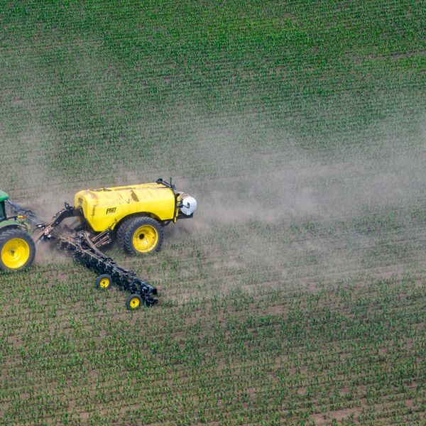 a tractor in a field spraying agrochemicals.