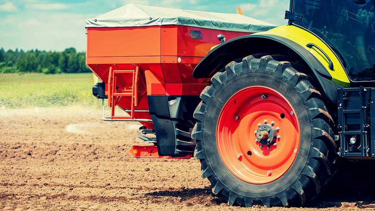 A tractor putting fertilizer on a farm field