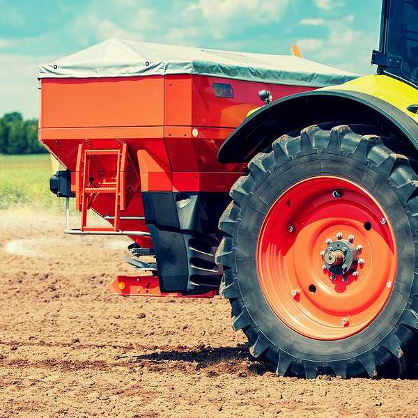 A tractor putting fertilizer on a farm field