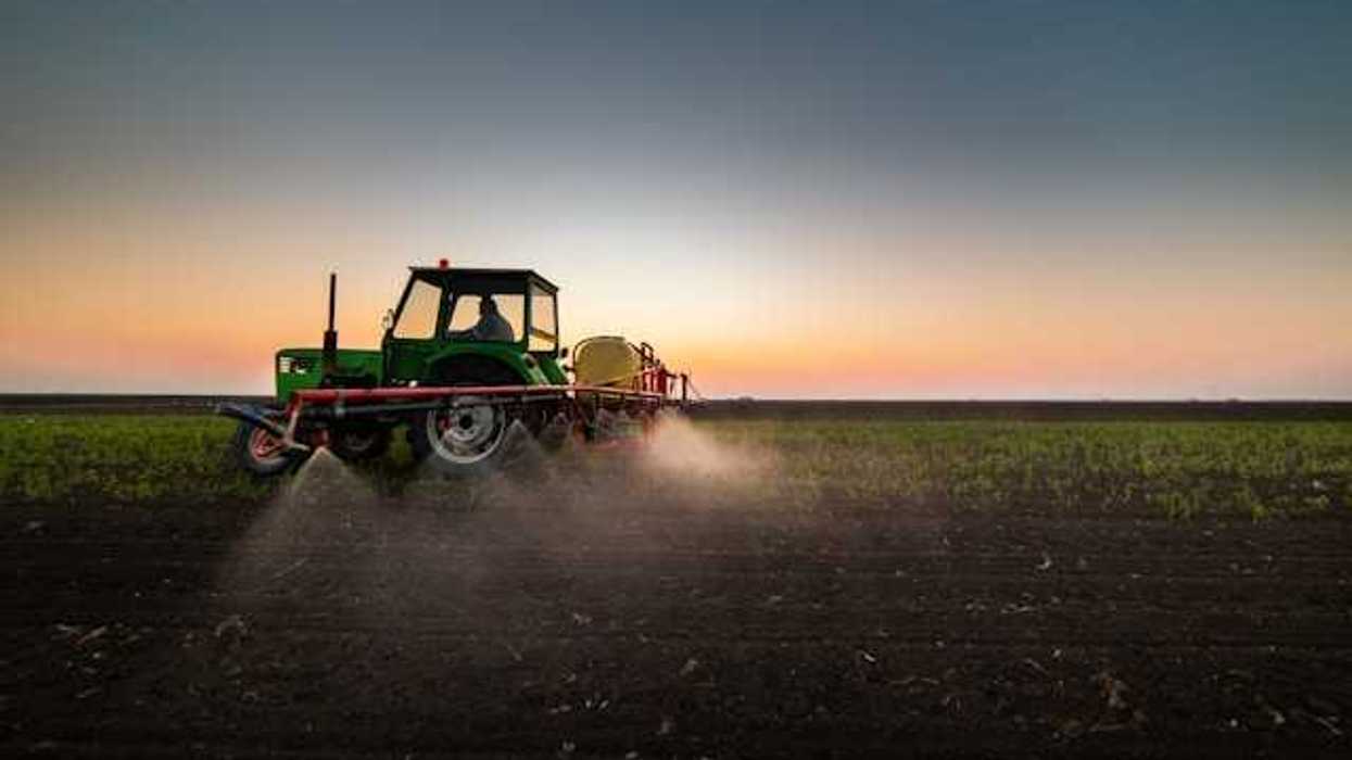 A tractor spraying pesticides on a farm field