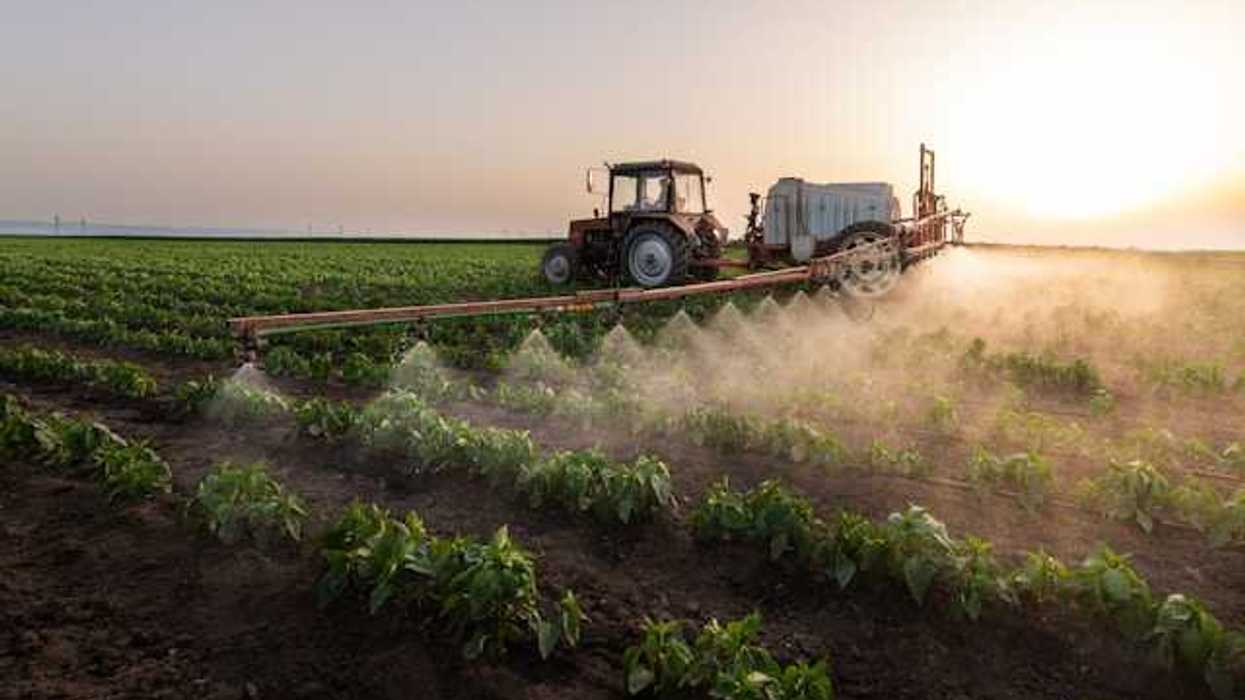 A tractor spraying pesticides on a field