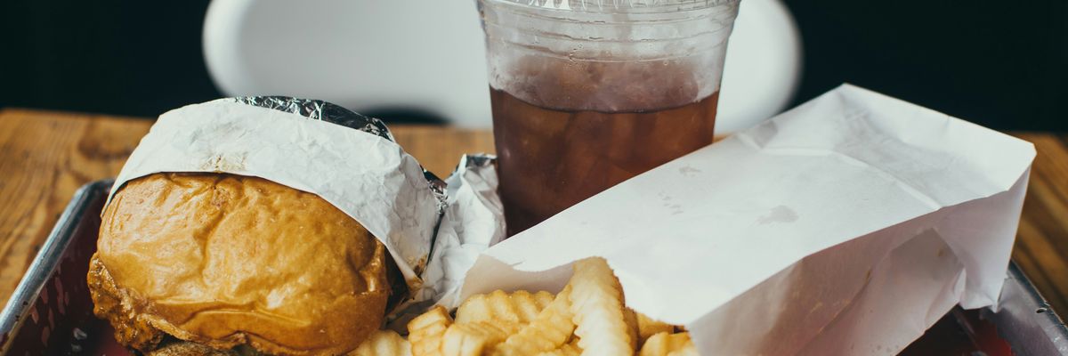 a tray of fast food and a drink in a plastic container