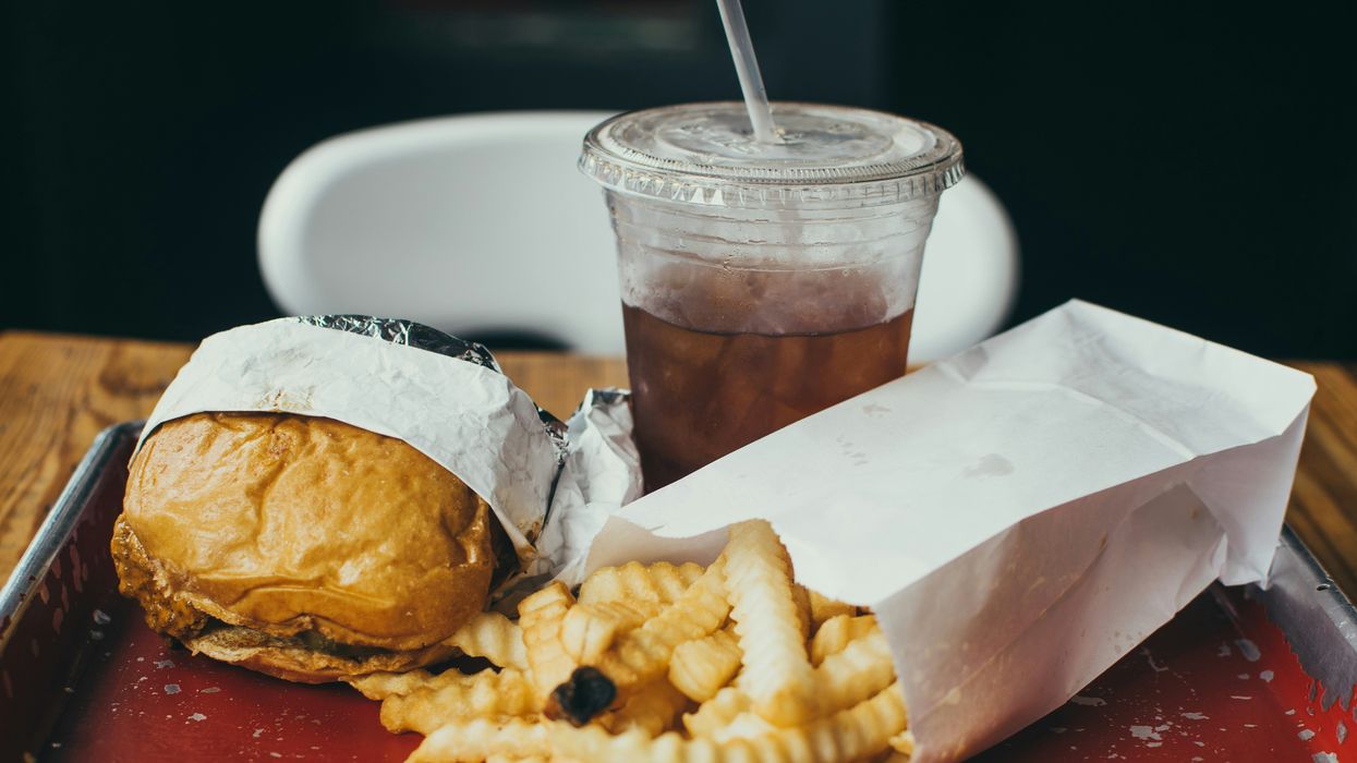a tray of fast food and a drink in a plastic container