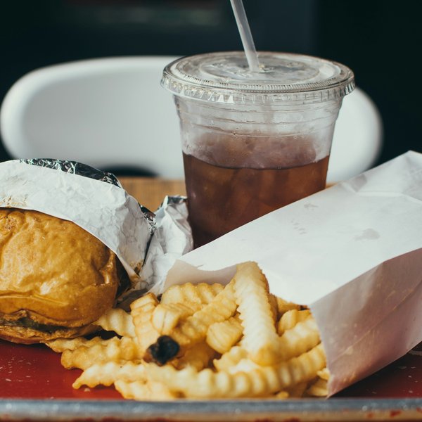 a tray of fast food and a drink in a plastic container