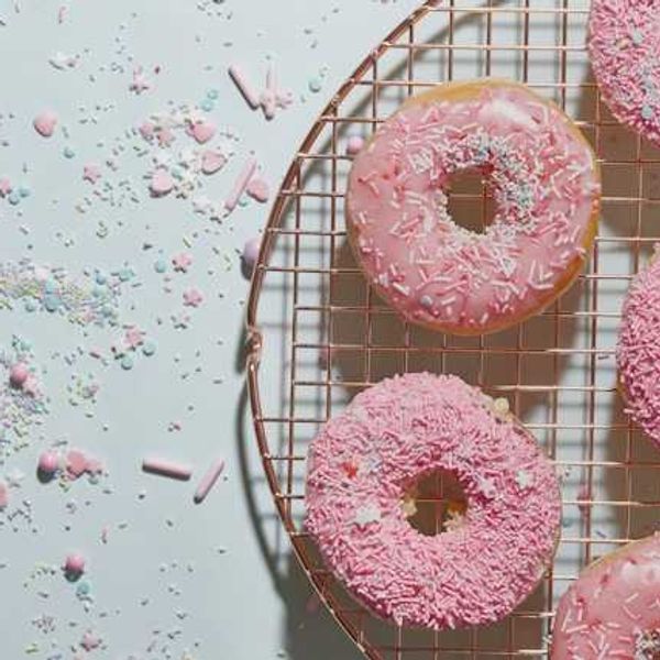 A tray of pink donuts
