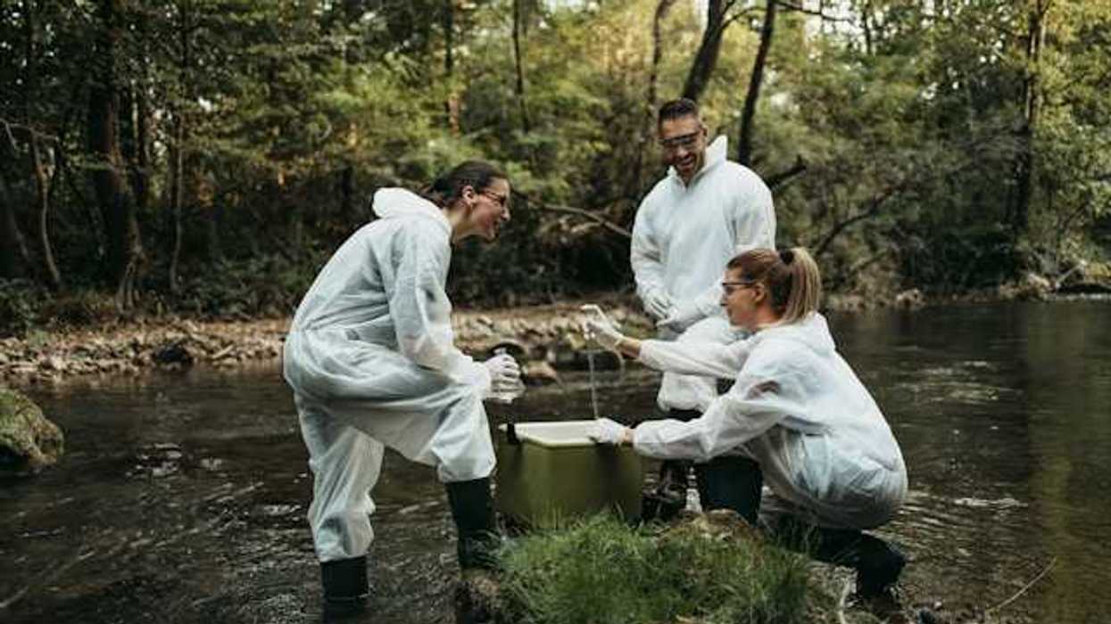 A trio of scientists in a creek testing the water