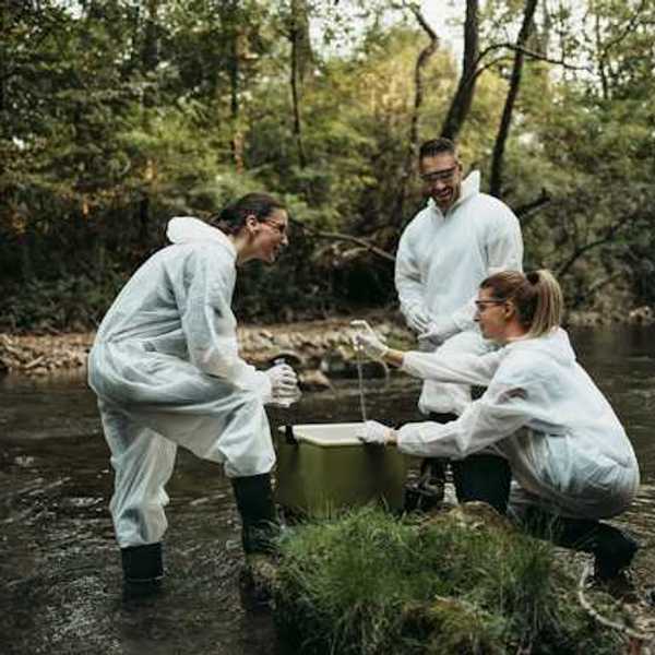 A trio of scientists in a creek testing the water
