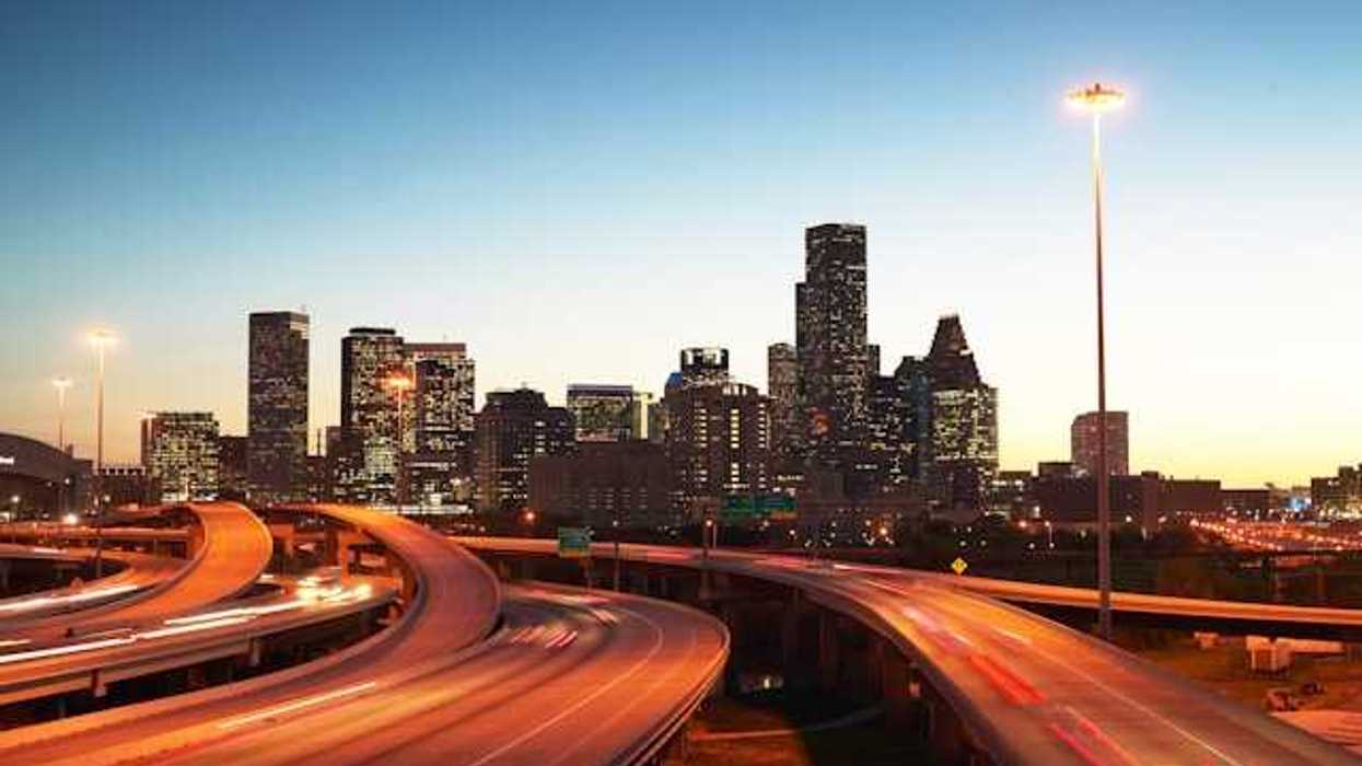 A view at dusk of highways leading into an urban downtown with skyscapers