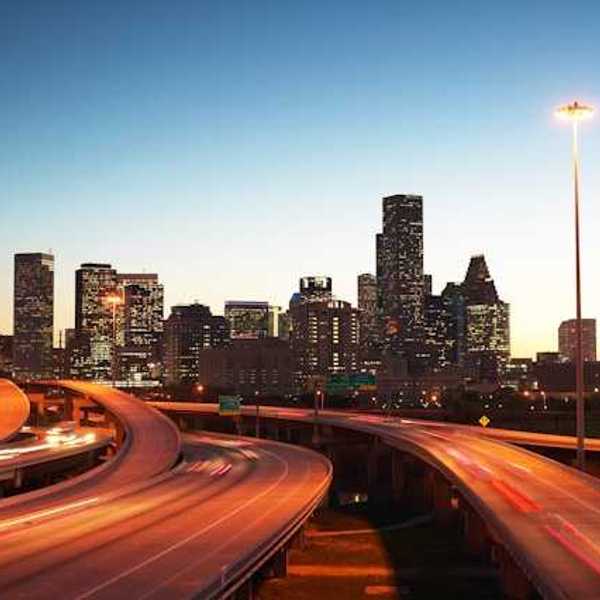 A view at dusk of highways leading into an urban downtown with skyscapers